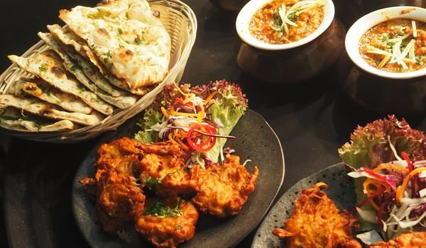 Naan bread, pakoras and curries on the table